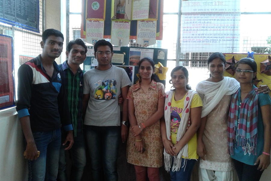 भीत्तिपत्रक के साथ विद्यार्थी